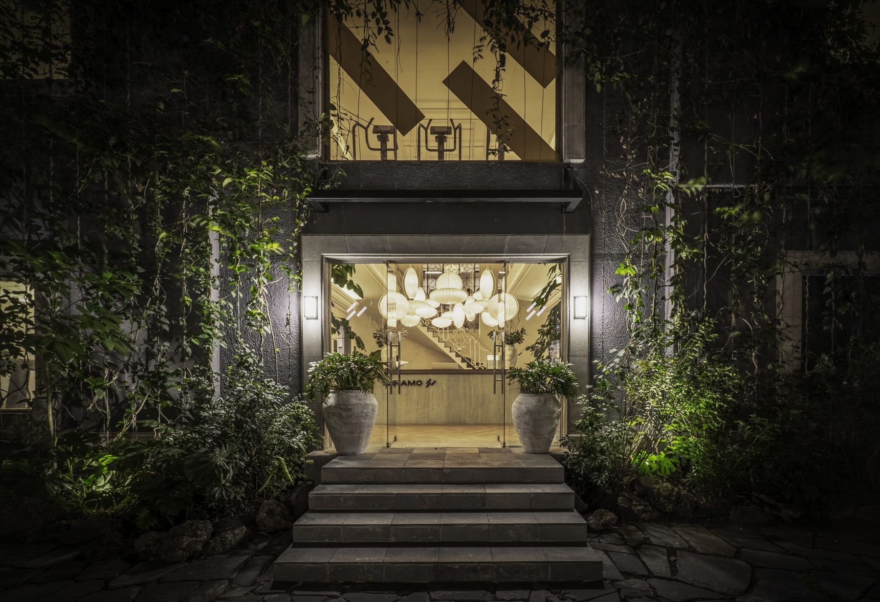 La fachada de DINAMO de noche, con la entrada iluminada